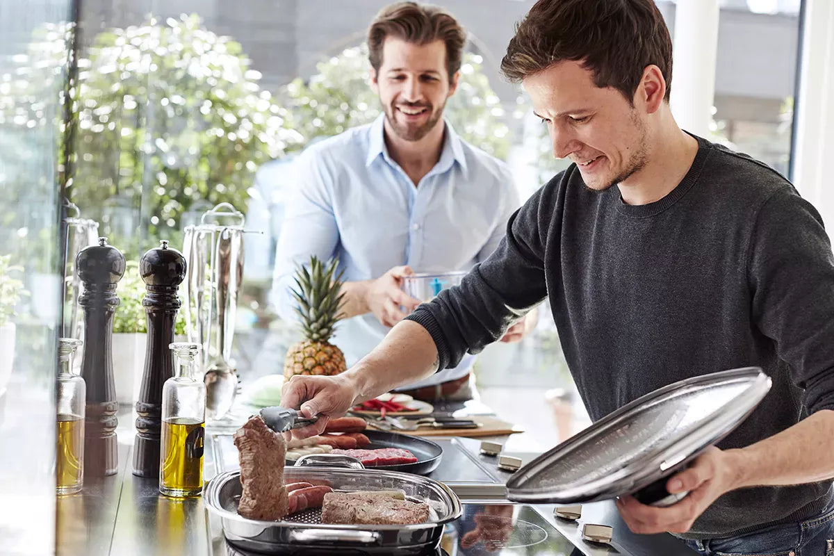 uomo che cuoce carne su griglia AMC
